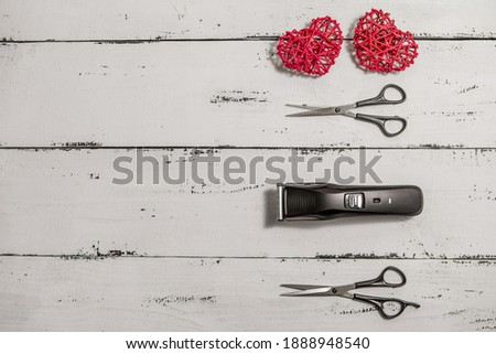 composition with hairdressing tools and colored rattan hearts on a worn white wooden background. Template for a postcard or information about a hair salon. flat lay, copy space