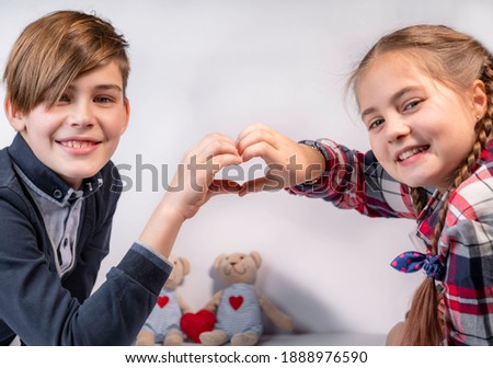 Heart shape made of boy and beloved girl hands, Valentine Day. Smiling beauty teens happy, selective focus