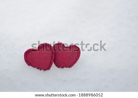red felt hearts on white fluffy snow, mock up for Valentine's day card, free space, love and fidelity concept
