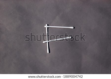 F letter sign by cotton bud stick, pure cotton on Grey background. Text element, lettering symbol in cotton bud. F text by pure cotton bud on grey background for education or business icon,  logo