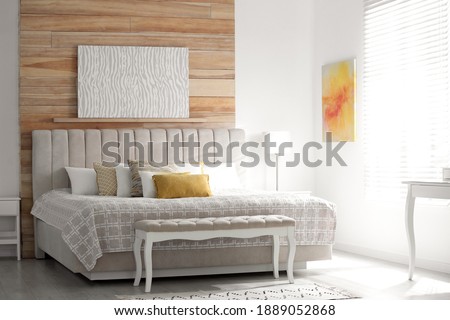 Comfortable bed with soft color pillows indoors
