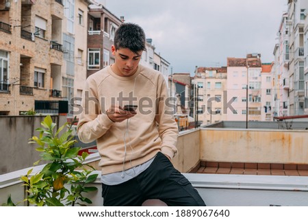 young teenager with mobile phone on the terrace of the building