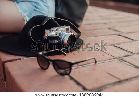 sunglasses and a traveler's camera lying near the girl