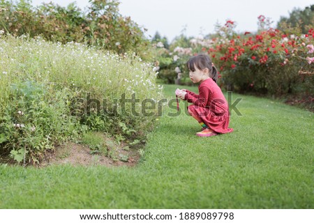 young girl taking photo in the summer garden morning 