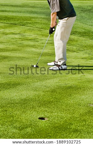 Photo of Male Golfer Putting for Birdie on gol course