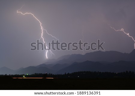 A picture of lightning in the sky and mountains