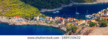 Assos village in Kefalonia, Greece. Turquoise colored bay in Mediterranean sea with beautiful colorful houses in Assos village in Kefalonia, Greece, Ionian island, Cephalonia, Assos village. Royalty-Free Stock Photo #1889150632