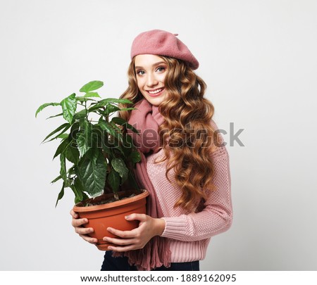 lifestyle, emotion and people concept: Beautiful girl with long wavy hair holding a flower over white background