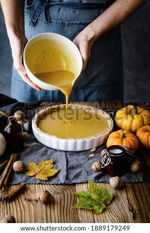 Baker pouring pumpkin puree into a plate closeup