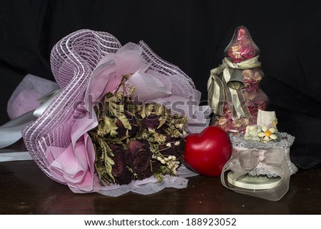 Still life of love with dry roses ,heart ,the jar of flowers and music box