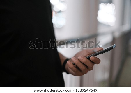 Closeup of male hand holding modern smartphone, man's hand using cellphone at night city, bokeh light