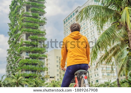 man looks at Eco architecture. Green cafe with hydroponic plants on the facade. Ecology and green living in city, urban environment concept. Modern building covered green plant Royalty-Free Stock Photo #1889267908
