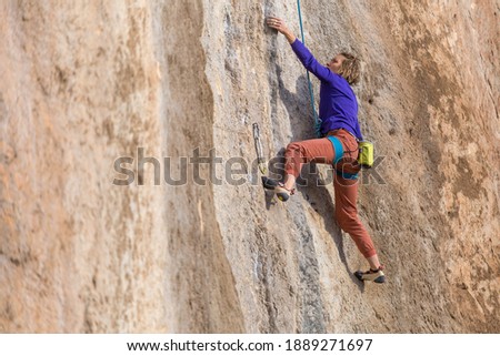 sport rock climbing in nature. the girl climbs the cliff with the insurance. active rest in turkey. climbing in the mountains.