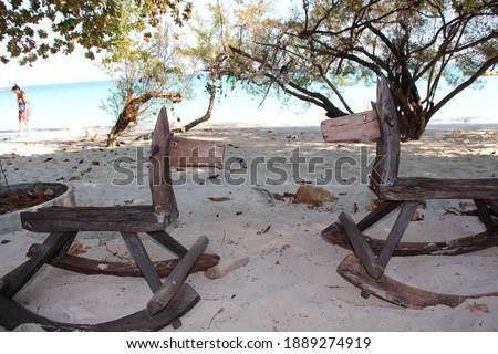 two wooden rocking horses at the white beach with turquoise water