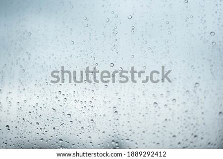Rainy drops on window glass with  sky background
