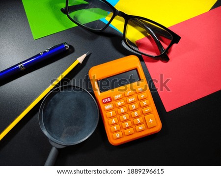 Selective focus.Calculator,pencil,pen,eye glasses and calculator on a black background.Business concept idea.