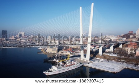 A ship passes under the bridge in Vladivostok. The bridge through a bay Golden Horn.Russia