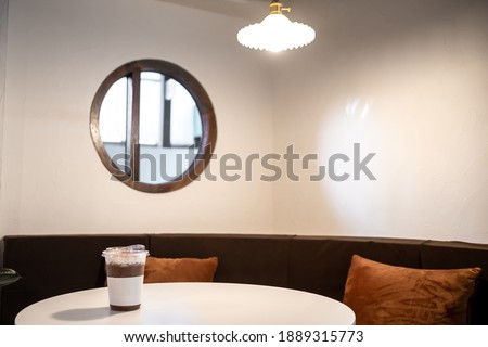Iced chocolate on plastic mug cup on wooden table in Cafe shop mood minimal interior design Blur background. Minimalistic Scandinavian interior