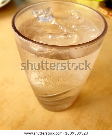 Close up picture of a glass of iced cold water on the table in the restaurant.