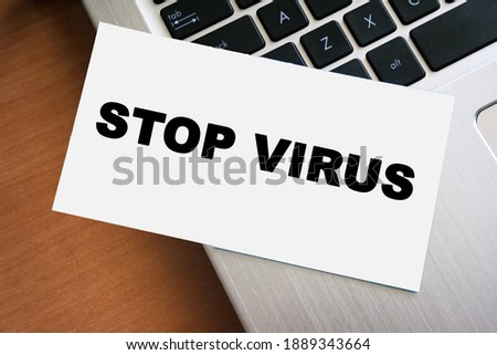STOP VIRUS inscription on white paper note on laptop keyboard. Goodbye coronavirus. Closeup message.