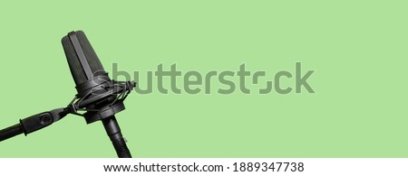 Professional microphone isolated on green background, podcast or website banner with copy space Royalty-Free Stock Photo #1889347738