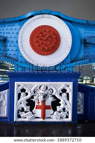 emblem and crest of the city of london on tower bridge at night
selective focus
Translation: "Lord directs us"