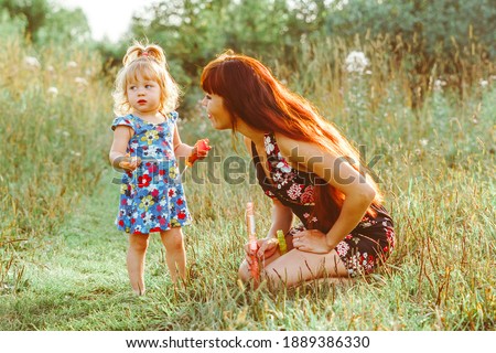 Cute baby in her mothers arms outdoors portrait. Happy mom and baby photography concept