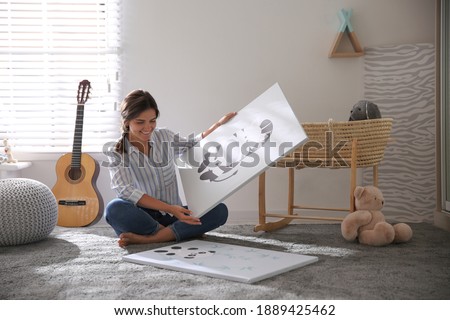Decorator with pictures on floor in baby room. Interior design