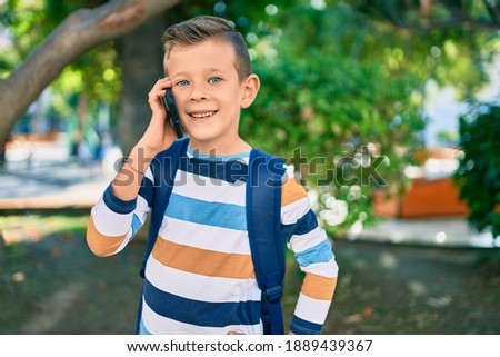 Adorable caucasian student boy smiling happy talking on the smartphone at the park.