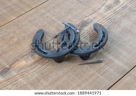 Metal horseshoes for the little ponies and nails for shoeing horses on the boards with bokeh effect