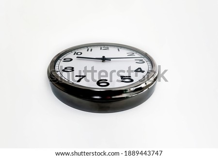 Analog clock with the hands hanging on a white wall seen from below. Time concept. Hurry and deadlines.