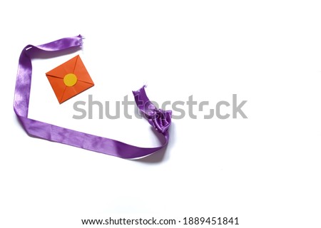 Orange envelope and purple ribbon isolated on a white background. Valentine's day gift. Valentine's day concept. Space for text.
