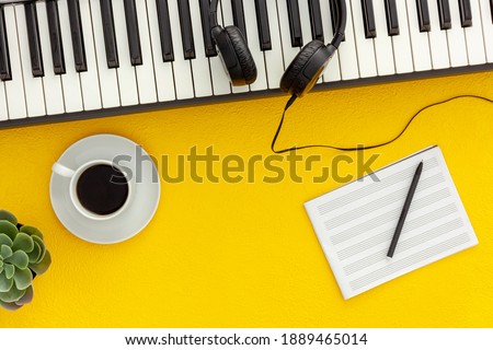 Desk of musician for songwriter work set with headphones and synthesizer 