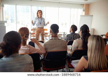 Group of business people carefully listening to a lecturer in a working atmosphere at seminar. People, company, job, business concept. Royalty-Free Stock Photo #1889468716