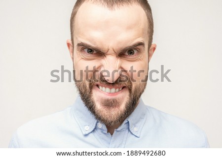 Gloating bearded man, portrait of an angry man with a grimace on his face, white background, close-up Royalty-Free Stock Photo #1889492680