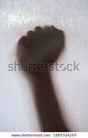 Shadow of a hand clenched into a fist