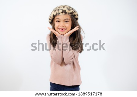 Portrait of pretty little girl in pink sweater smiling over white background