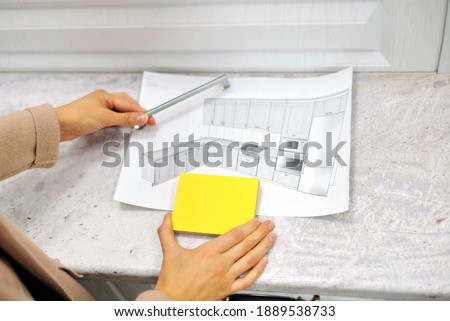 soft focus On the table is a mock-up of a kitchen, an example of a palette of facades and drawer bodies and a handle for the door. girl orders furniture for the kitchen in the salon. close-up.