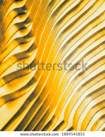 Abstract architecture detail background. Colored golden yellow piled metal plates macro photo wallpaper for finance and business concepts. Selective closeup focus, blurred foreground, vertical design