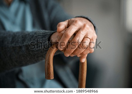 Close up of senior disabled woman hands holding walking stick. Detail of old woman hands holding handle of cane. Old lady holding walking stick. Royalty-Free Stock Photo #1889548966