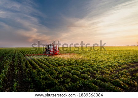 Tractor spraying pesticides on soy field  with sprayer at spring Royalty-Free Stock Photo #1889566384