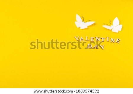 Valentine's Day yellow background, with pair of butterflies and text Valentine Day. 