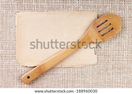 Kitchen wooden spoon and an old sheet of paper for text.