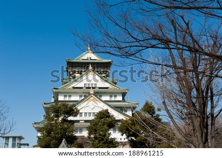 Osaka Castle with plum blossom trees in the foreground at the start of the Sakura in Japan.