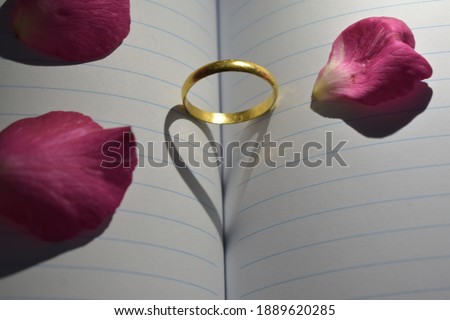 Wedding ring casting a heart-shaped shadow on the diary page. Valentine Concept