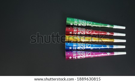 Paper Blow Horns in red ,green, gold, blue, purple color for New Year and christmas party on black background.No people
