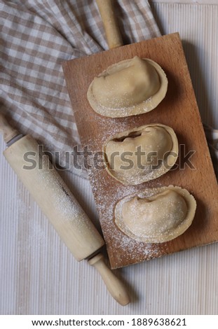 Flat-shaped savory cake filled with chopped and seasoned food with onion and tomato that is baked in the oven, known as empanada. Traditional Argentine, Spanish and Portuguese food.