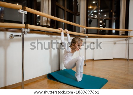 the girl is engaged in gymnastics in the gym