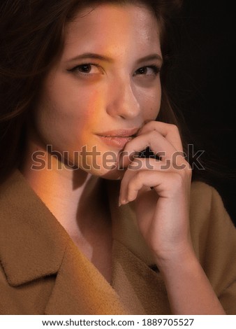 beautiful portrait of one young woman, smrik, posing in photo studio with white background and rainbow light effect created from prism.