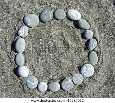 round pebble frame lying on a sand